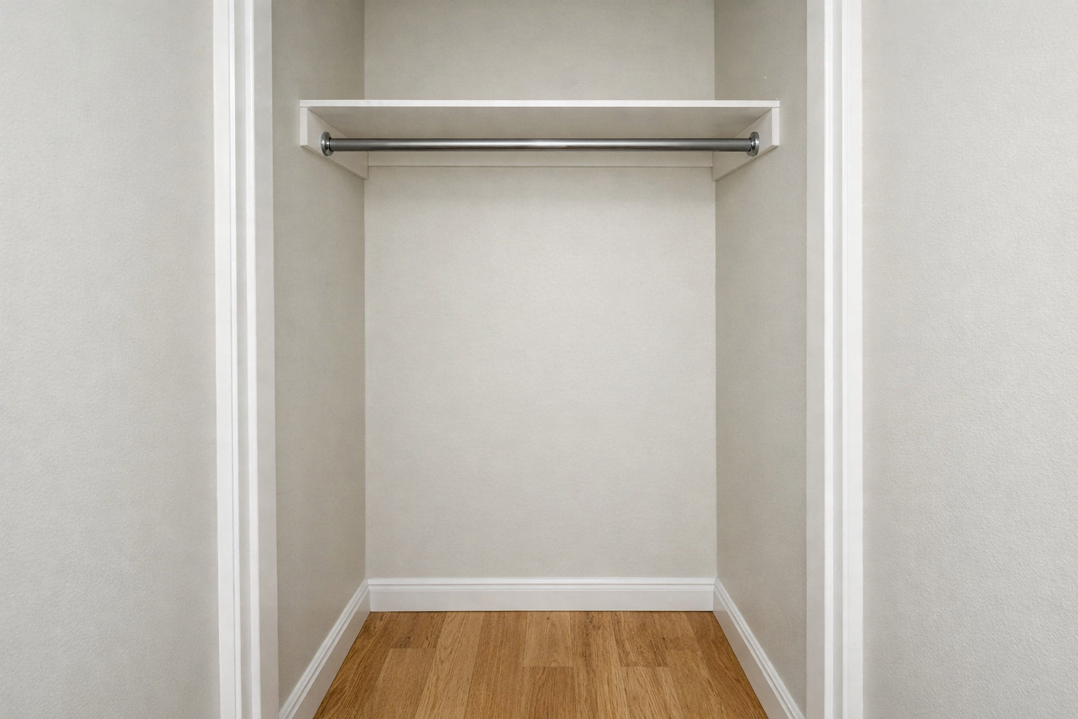 Reach-in closet with single hanging rod and shelf.