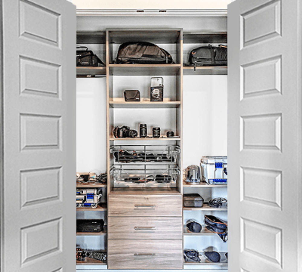 A grey and brown men's closet organized with shelving and drawers.