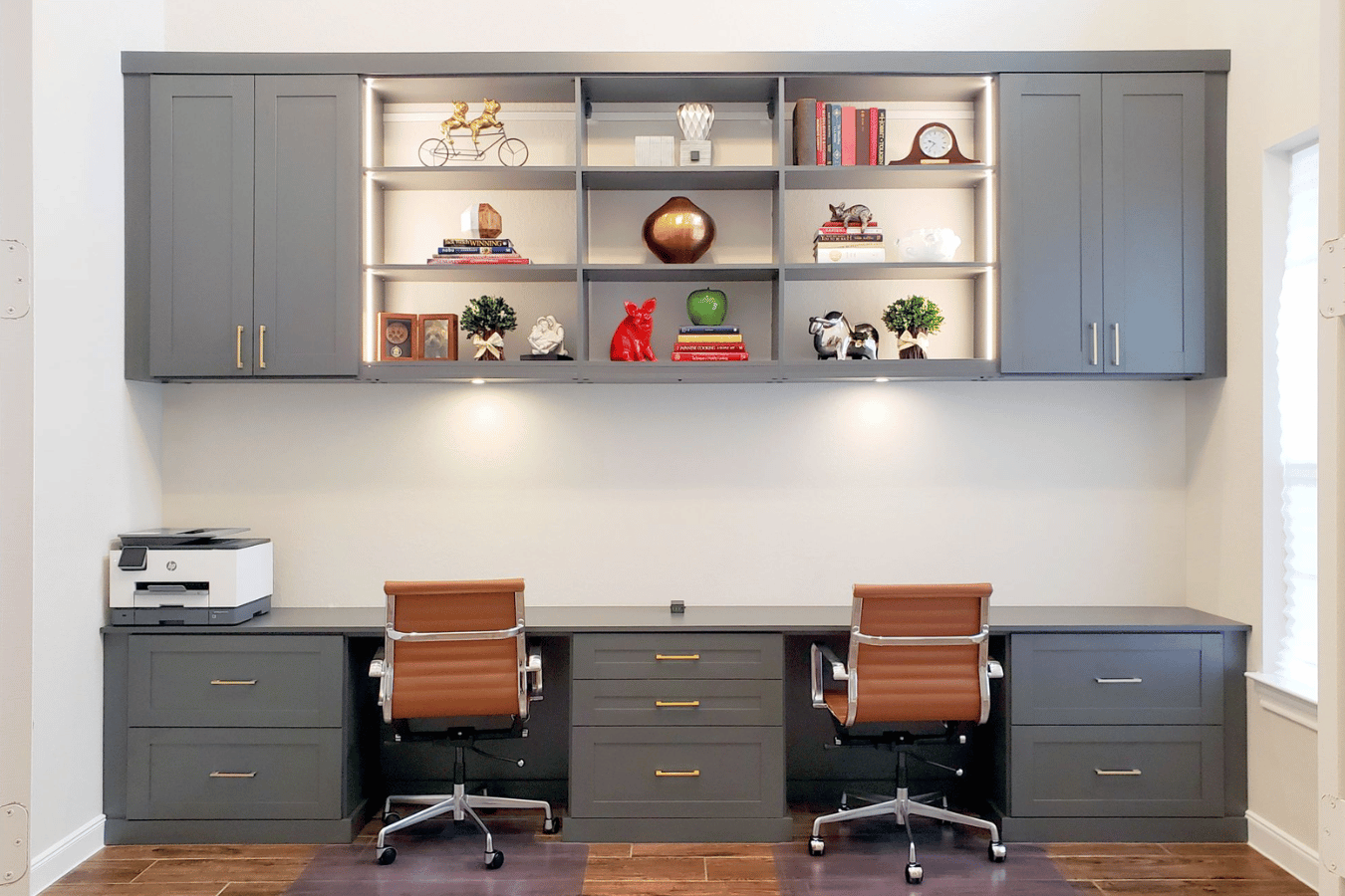 Custom home office with built-in cabinetry, open shelving, and integrated workspace for two